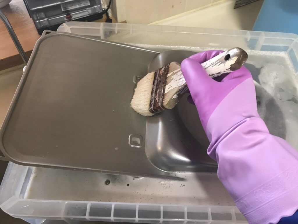 外した部品をブラシで洗浄する様子