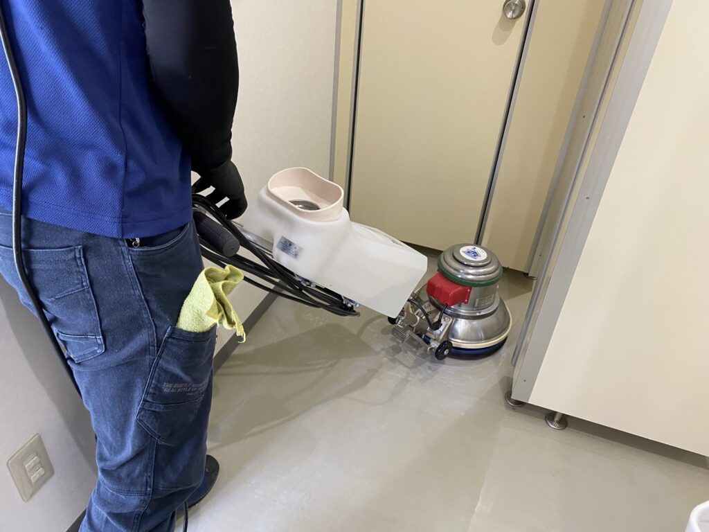 所沢市の事務所で、ポリッシャーを使って床を洗浄している様子