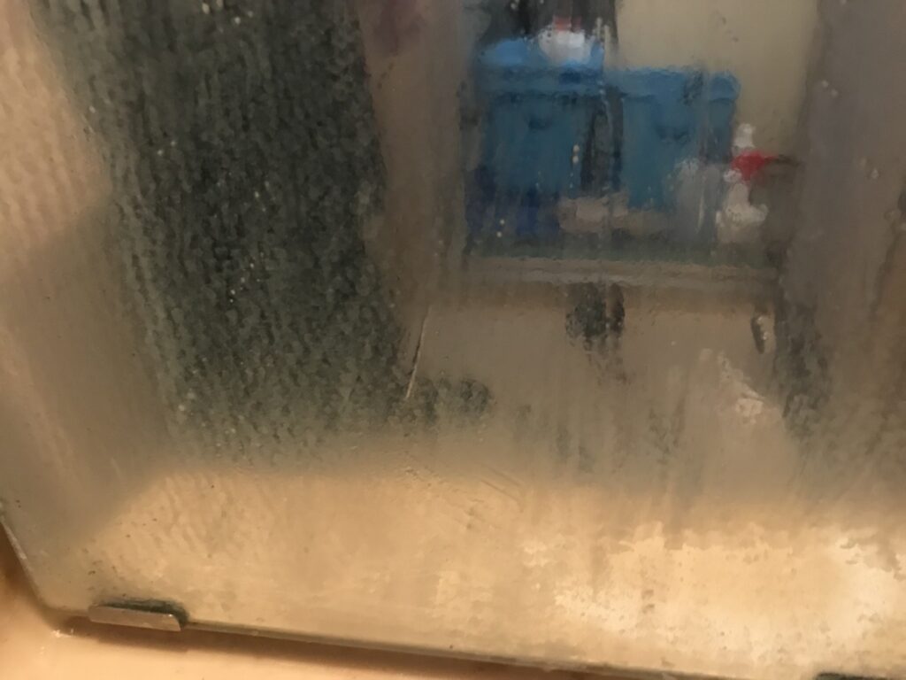 浴室の鏡に水アカが付着した清掃前の状態
